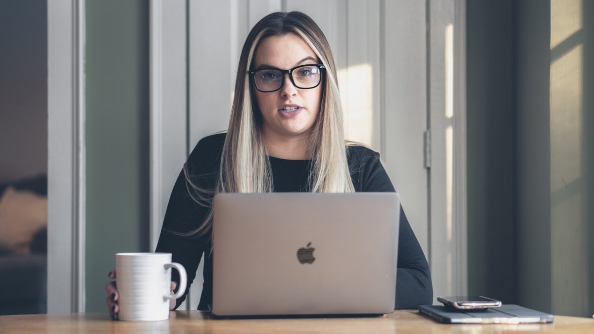 woman in black framed eyeglasses using macbook