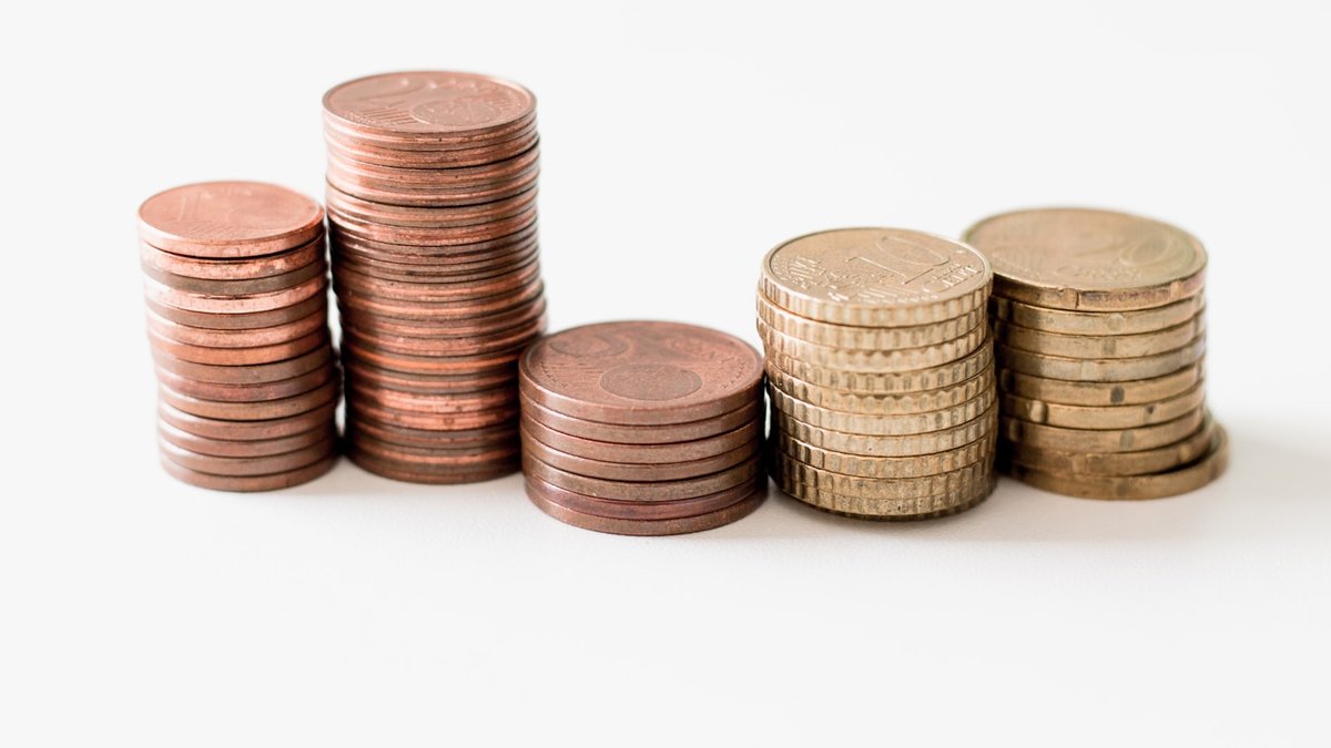 stacked round gold-colored coins on white surface