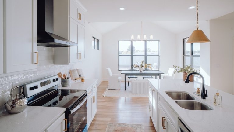 a kitchen with a sink, stove, and a window