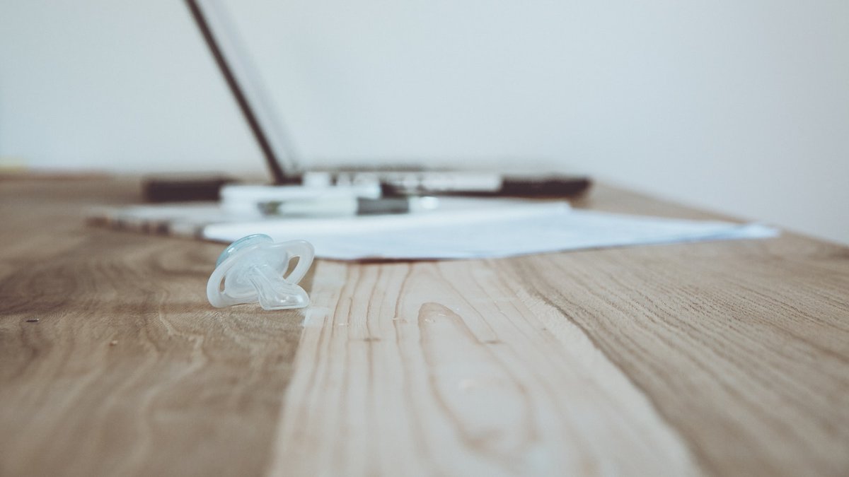 silver macbook on brown wooden table