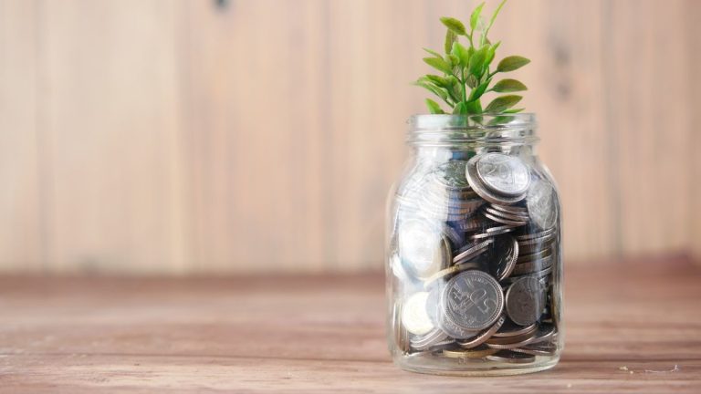 a glass jar filled with coins and a plant