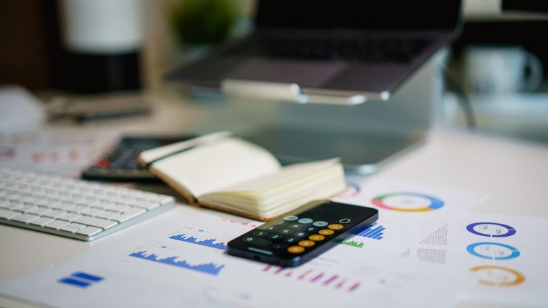office desk with smartphone and financial charts