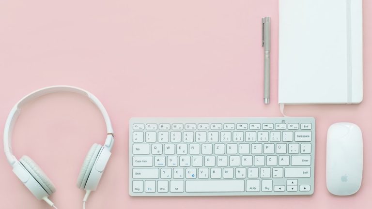 white Apple Magic Mouse beside of Magic Keyboard and headphones