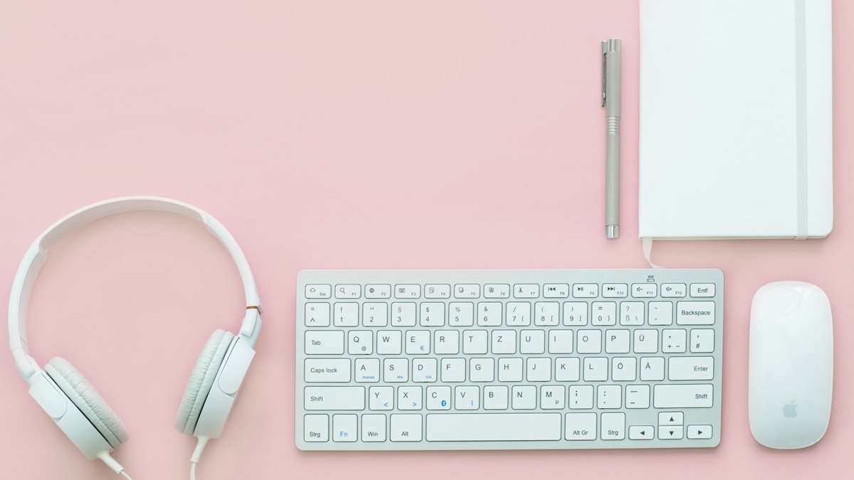 white Apple Magic Mouse beside of Magic Keyboard and headphones