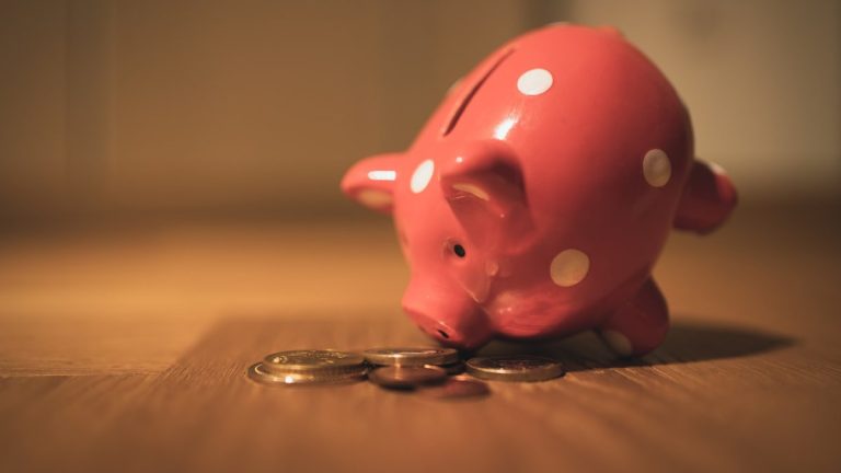pink pig coin bank on brown wooden table